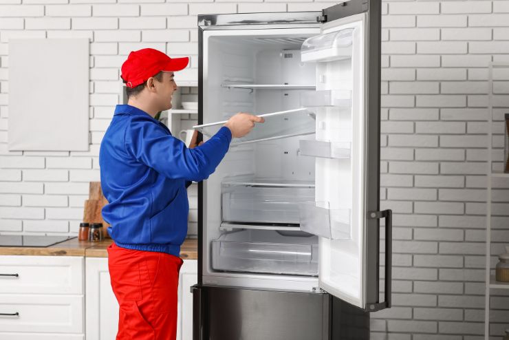 fridge servicing in Doha — technician inspecting refrigerator Qatar